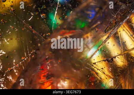 Macro texture of glass shards with bubbles, reflections, color lights and resin layers in closeup. Concept of texture for design, backdrop, poster, te Stock Photo