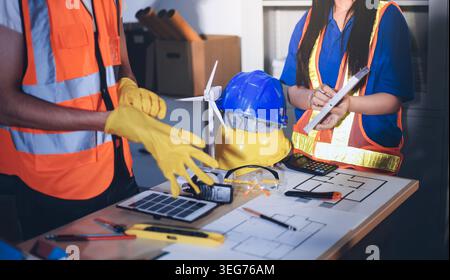 Two technicians inspect server racks in data center with tablet and fiber optic cable. Engineer and specialist discuss maintenance work in data center Stock Photo