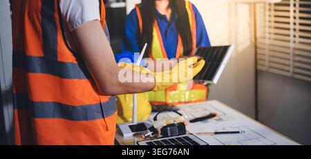 Two technicians inspect server racks in data center with tablet and fiber optic cable. Engineer and specialist discuss maintenance work in data center Stock Photo