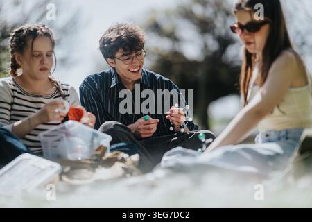 Friends studying science outdoors, young people sitting on grass with a molecular model Stock Photo