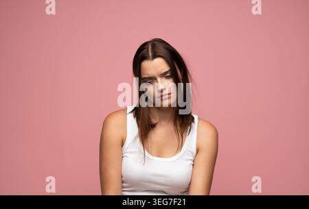 Young woman feeling sad and depressed, experiencing disappointment and emotional distress, looking down in despair Stock Photo