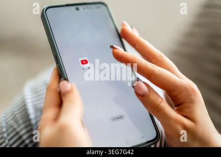 GNIEZNO, POLAND - May 06, 2026: Woman's Hands Holding Phone With Youtube Icon On Screen Stock Photo