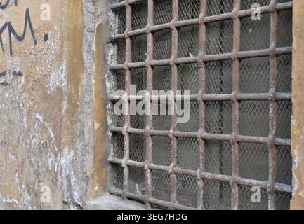BACKGROUND TEXTURE OF AN OLD WALL WITH A RUSTY METAL GRATE Stock Photo