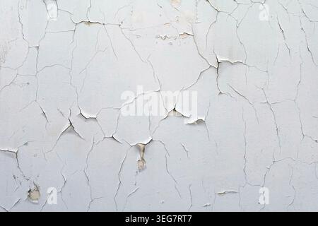 Cracked white wall chipped paint background with copyspace. Stock Photo