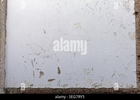 Empty weathered white wall background with exposed bricks and concrete frame. Stock Photo
