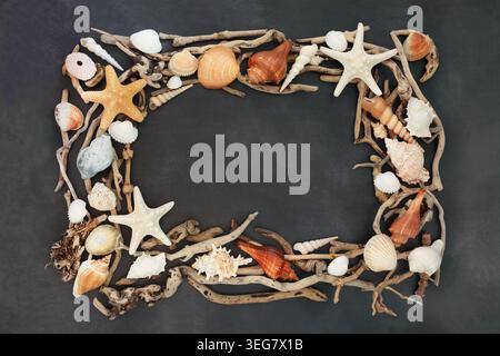 Shell driftwood wreath rustic seaside frame decoration on mottled gray background. Decorative coastal art decor border design of twisted curved wood. Stock Photo