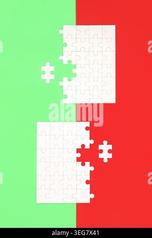 Jigsaw puzzle with missing piece on red green background. Opposites contrast duality theme. Business opportunities for teamwork. Stock Photo