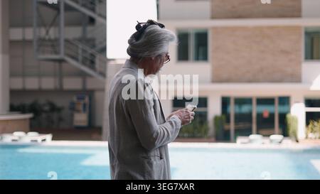 Senior man browsing phone outdoors, demonstrating digital literacy and leisure activity Stock Photo