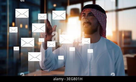 Man interacts with digital messages in an office setting during early morning hours Stock Photo