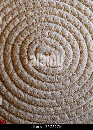 Woven natural fiber creates a detailed abstract background, showing a coiled design with visible interwoven ropes and stitches, highlighting rustic cr Stock Photo