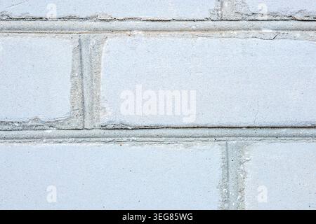 Textured gray concrete block wall featuring visible joints and seams, showcasing a uniform surface with subtle variations in color and texture Stock Photo