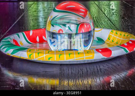 A solid glass ball on a dark surface captures reflected light. Stock Photo