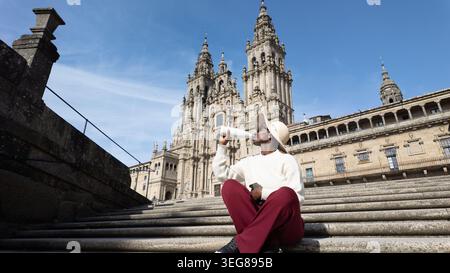 African woman in a sweatsuit and hat drinking from a reusable bottle on the Santiago Cathedral steps. Stock Photo