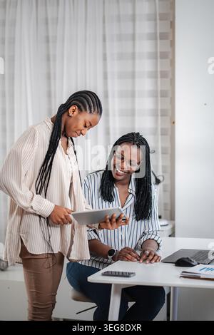 Women business professionals collaborating on digital tablet, sharing ideas Stock Photo