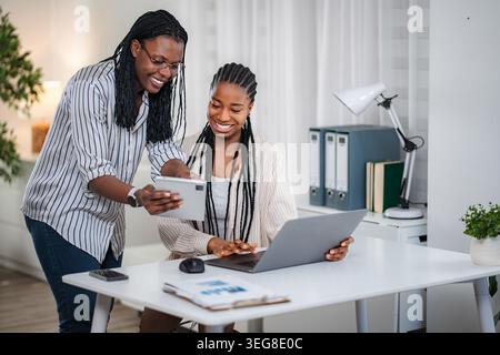 Young black businesswomen collaborating on a project in a modern office Stock Photo