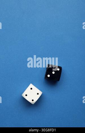 Two black and white dice on dark blue background. Game cube. Top view Stock Photo
