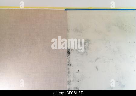Wall half covered with wallpaper beside unfinished plaster surface. Stock Photo