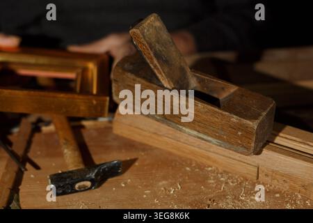Detailed View Of Hand Planing Wood With Shavings On Aged Workbench In Warm Light Stock Photo