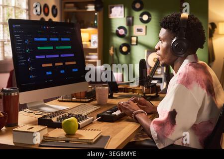 Black Young Man Editing Audio Workflow for Music Content Production Stock Photo