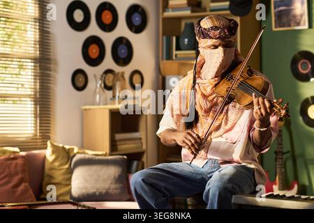 Black Young Man Playing Violin in Home Music Studio for Performance Stock Photo