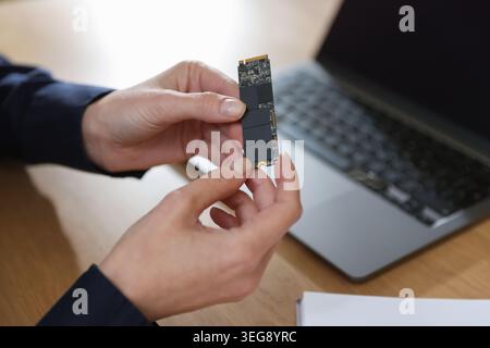 Woman with SD RAM at wooden desk, closeup Stock Photo