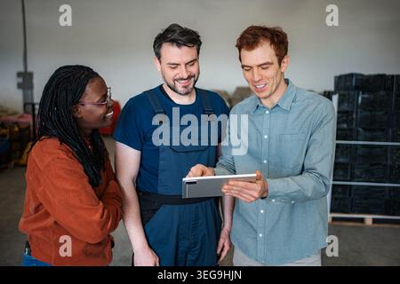 Warehouse workers collaborating on digital tablet for logistics management Stock Photo