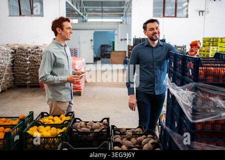 Workers checking produce in a food distribution warehouse Stock Photo