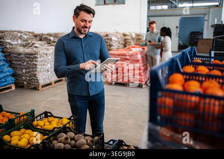 Man using tablet checking inventory in food warehouse Stock Photo