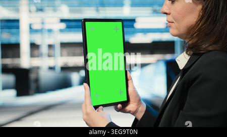 Green screen tablet used by data center admin to optimize server load balancing. Server farm IT specialist using mockup device to adjust system parameters and improve efficiency Stock Photo