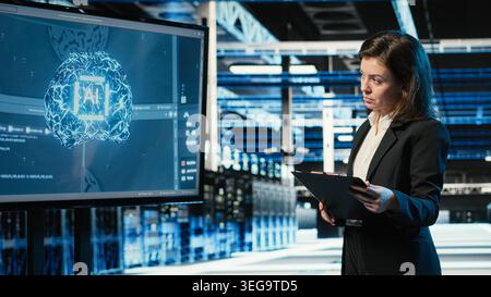 Data center engineer using artificial intelligence tech to monitor industrial automation systems. Server room IT expert using AI machine learning to oversee network performance Stock Photo