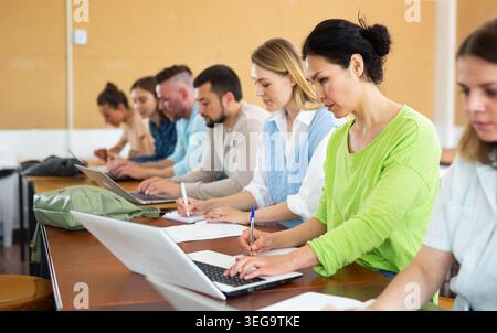 Group students listening and writing during business course Stock Photo