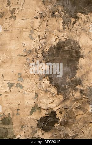 Old brick wall with severley damaged and patched stucco with intricate texture and detail Stock Photo