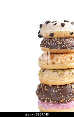 Vertical stack of assorted gourmet donuts with colorful glazes and toppings isolated on a clean light background with copy space. Sweet bakery dessert Stock Photo
