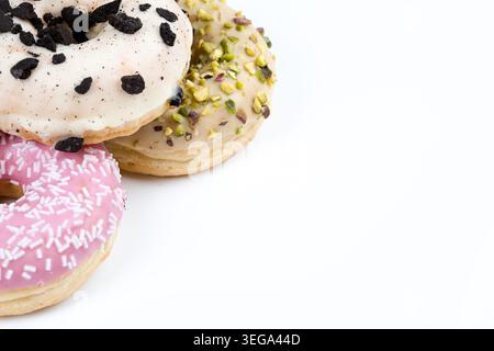 Minimal composition of assorted glazed donuts with different toppings including cookies and cream, pistachio, and pink sprinkles on a clean light back Stock Photo