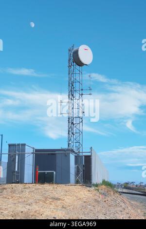 Telecommunications Tower With Microwave Dish Under Blue Sky Stock Photo