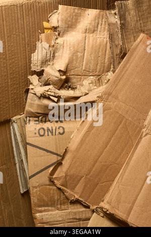 crushed brown corrugated cardboard boxes pile, torn wrinkled paperboard surfaces, full frame texture view, recycling environmental waste management Stock Photo