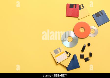 CD, floppy disks, SD cards and USB flash drives on yellow background Stock Photo