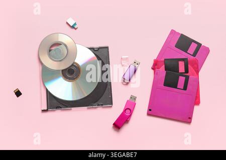 CD, USB flash drives and floppy disks on pink background Stock Photo
