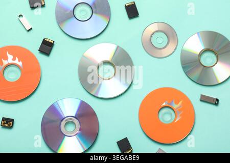 Composition with CD disks, USB flash drives and SD cards on turquoise background Stock Photo