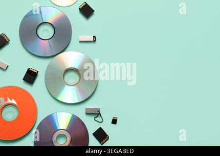 Composition with CD disks, USB flash drives and SD cards on turquoise background Stock Photo