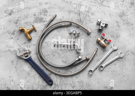 Composition with set of plumber's items on grey grunge background Stock Photo