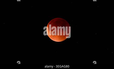 Blood moon during a lunar eclipse in the night sky. The moon appears red as it is shadowed by the Earth Stock Photo