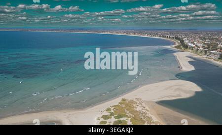 This stunning aerial photograph showcases a tranquil coastal landscape, featuring the gentle waves of the ocean lapping against sandy shores. A wide e Stock Photo