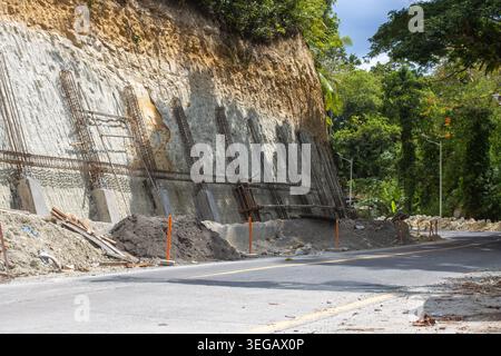 Retaining Wall Construction Site Along a Tropical Road with Steel Reinforcement Bars and Concrete Foundation, Bohol, Philippines Stock Photo