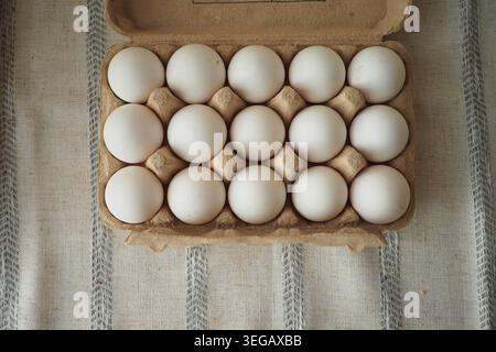 Eggs placed neatly in a carton on a kitchen table Stock Photo