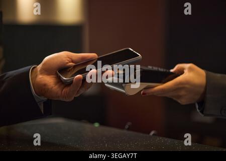 Adult Customer Making Contactless Payment at Hotel Reception Stock Photo