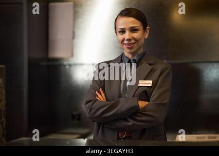 Portrait of Adult Woman Hotel Administrator Posing at Reception Stock Photo