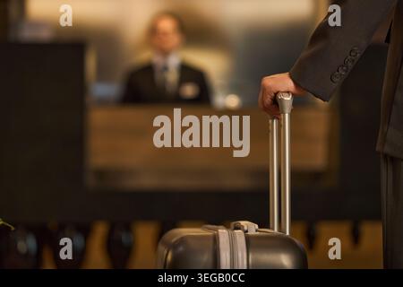 Person Checking in at Hotel Reception for Business Travel Stock Photo