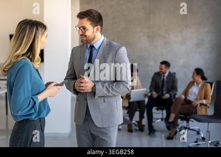 Two happy diverse multiethnic business team people working, talking in corporate office Stock Photo