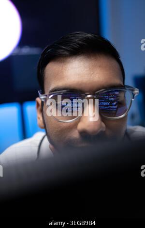 Vertical Portrait Of Indian Software Developer With Code Reflection On Glasses Stock Photo